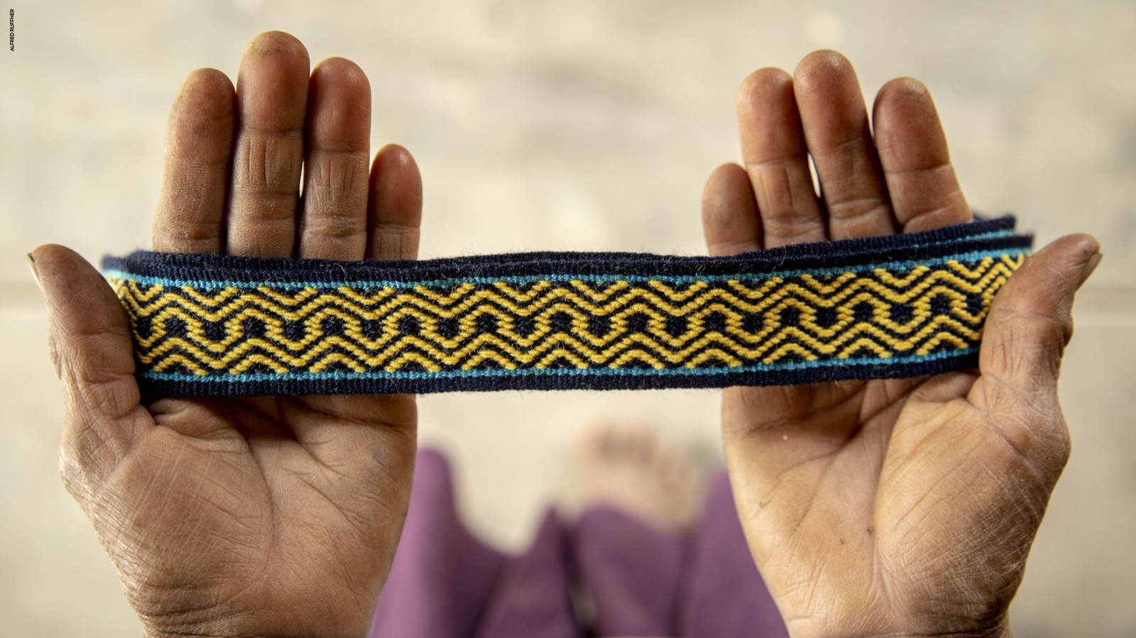 Manos sosteniendo textil tejido