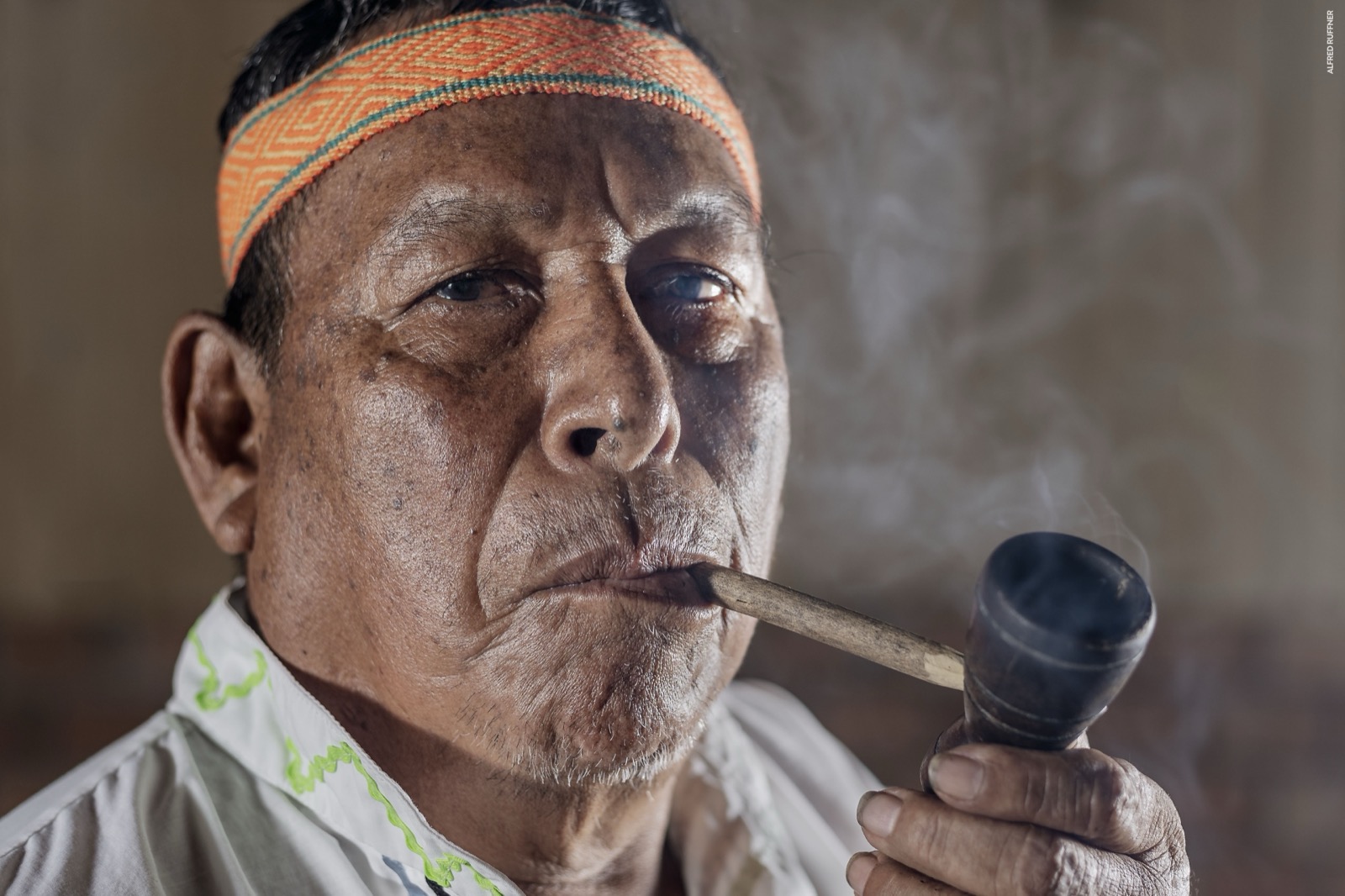 Anciano indígena fumando pipa