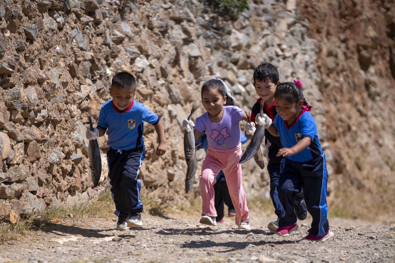Niños corriendo con pescado