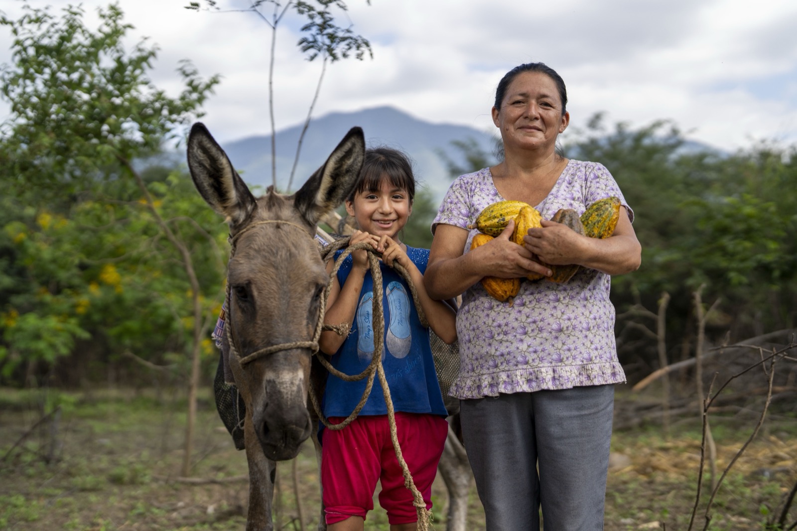 Mujer y niña con burro y cacao
